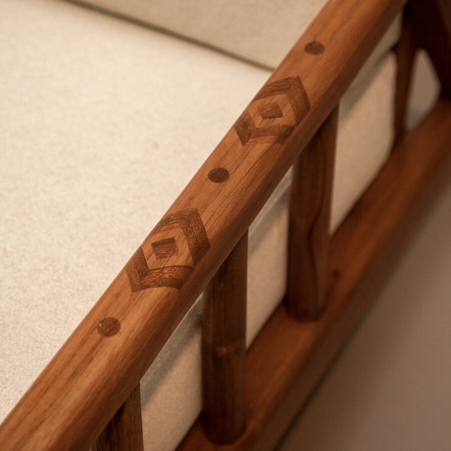 Silla con estructura en madera teca con espaldar en listones macizos e incrustaciones en guadua en los apoyabrazos. Asiento y espaldar tapizado con espuma de alta densidad.