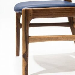 Silla AALTO en madera maciza de nogal cafetero tapizada en cuero sintético azul oscuro, detalle del asiento y la estructura, hecha a mano por Canorá en Bogotá
