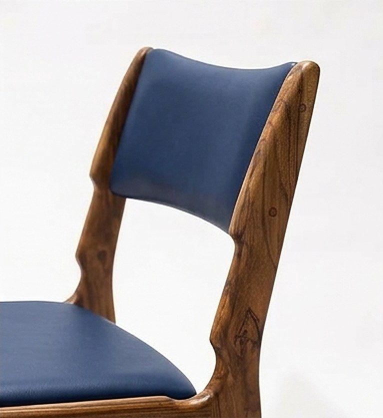 Silla AALTO en madera maciza de nogal cafetero tapizada en cuero sintético azul oscuro, detalle del espaldar, hecha a mano por Canorá en Bogotá