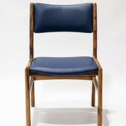 Silla AALTO en madera maciza de nogal cafetero tapizada en cuero sintético azul oscuro, vista frontal, hecha a mano por Canorá en Bogotá