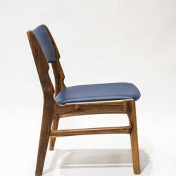 Silla AALTO en madera maciza de nogal cafetero tapizada en cuero sintético azul oscuro, vista lateral, hecha a mano por Canorá en Bogotá